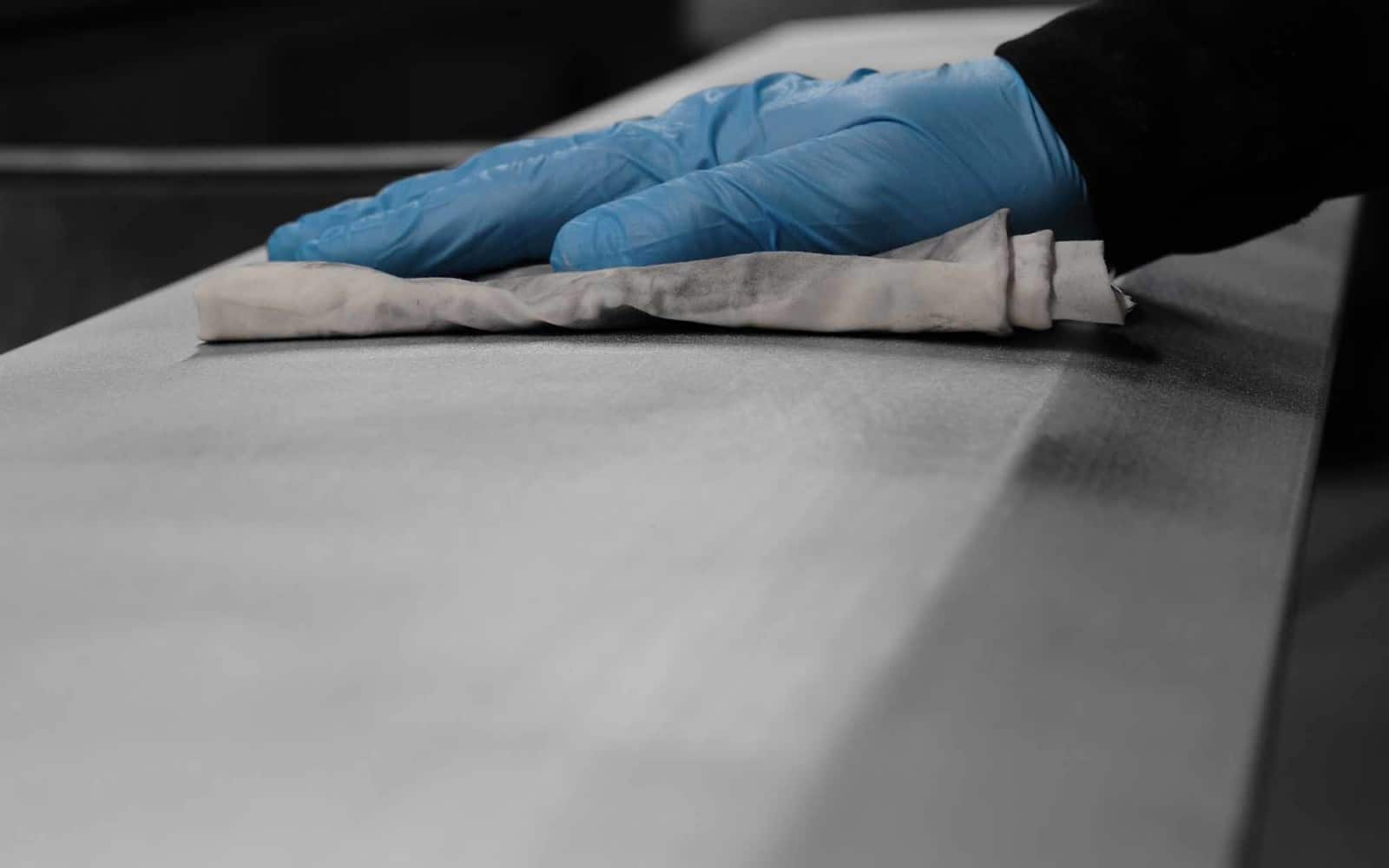 CLR_hand with glove using a rag to wipe off surface