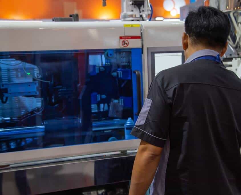 plastic injection molding worker using a large machine